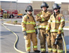 Three firefighters in uniform looking into camera smiling