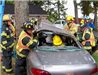Firemen using jaws of life to open vehicle and remove victim
