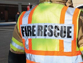 Image of the back of a firemen with Fire Rescue on yellow vest